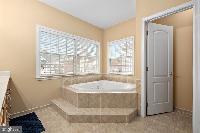 bathroom with vanity, tile patterned flooring, and a relaxing tiled tub