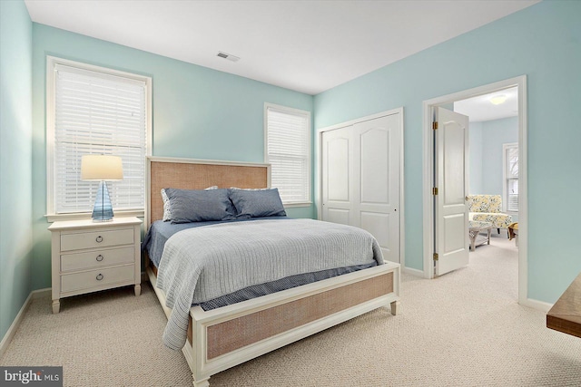 bedroom with light carpet and a closet