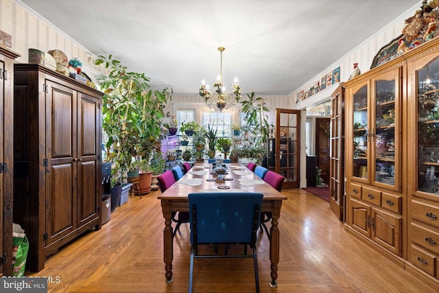 dining area featuring light parquet floors, ornamental molding, and a chandelier