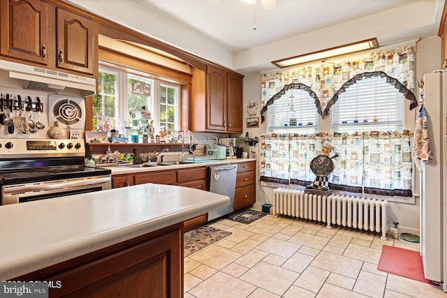 kitchen featuring ceiling fan, radiator, appliances with stainless steel finishes, and sink