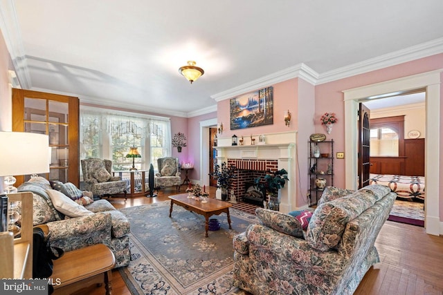 living room with a brick fireplace, crown molding, and hardwood / wood-style flooring