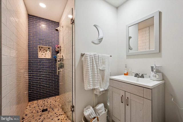 bathroom with vanity and a tile shower