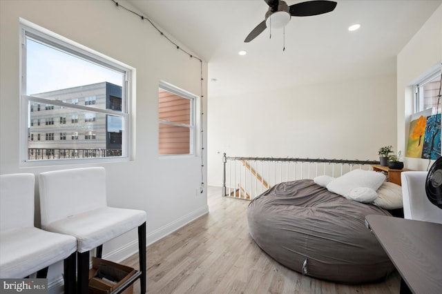 sitting room with ceiling fan and light wood-type flooring