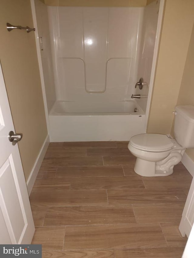 bathroom featuring hardwood / wood-style floors, shower / bath combination, and toilet