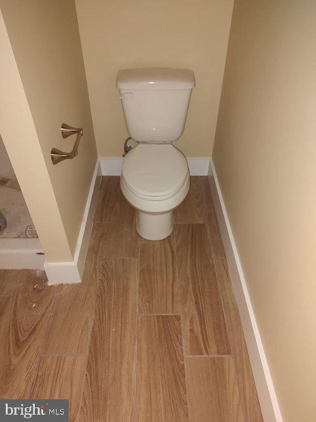 bathroom with hardwood / wood-style floors and toilet