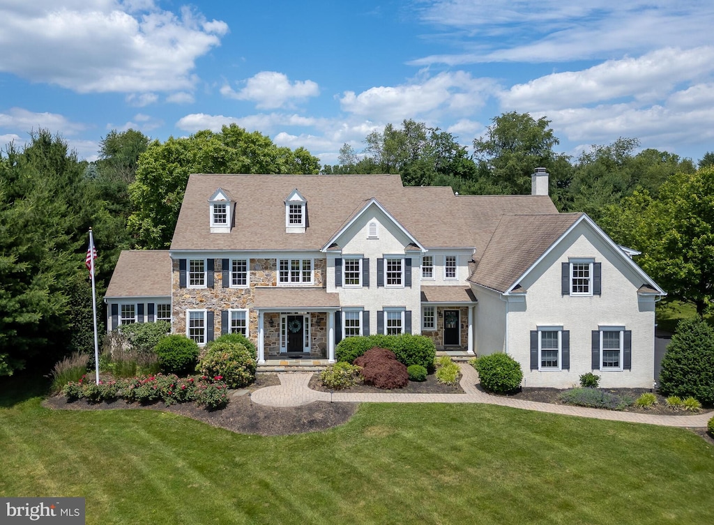 colonial inspired home with a front lawn