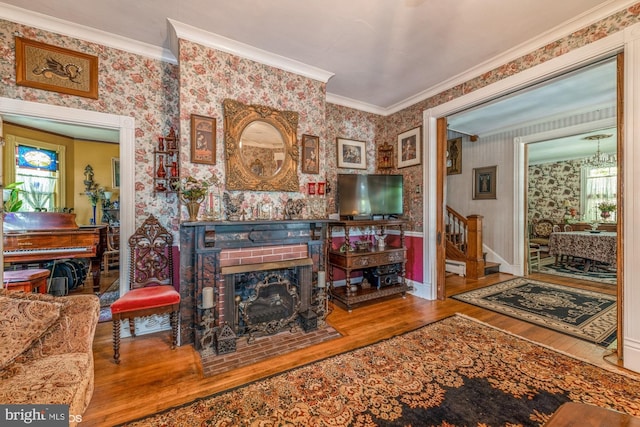 living room with hardwood / wood-style floors, ornamental molding, and a fireplace