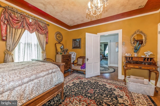 bedroom featuring wood-type flooring, ornamental molding, and a notable chandelier