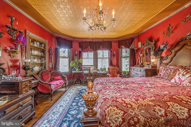 bedroom with a chandelier, ornamental molding, multiple windows, and a tray ceiling