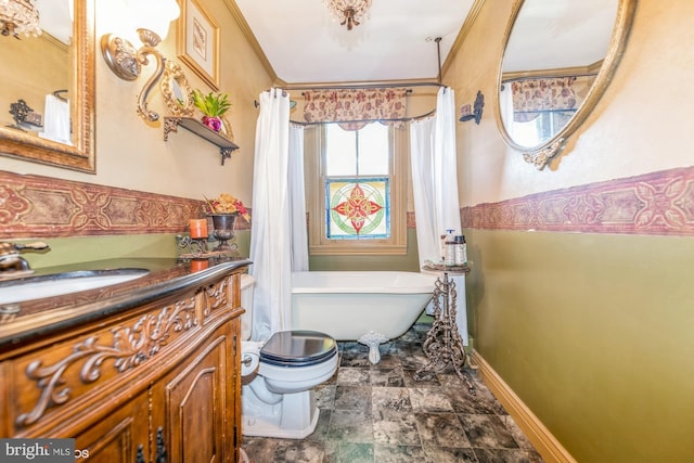 bathroom with toilet, vanity, crown molding, and a tub