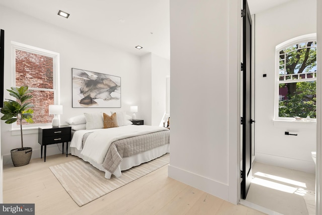 bedroom featuring light hardwood / wood-style flooring and multiple windows