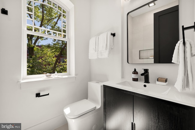 bathroom with vanity, toilet, and a wealth of natural light