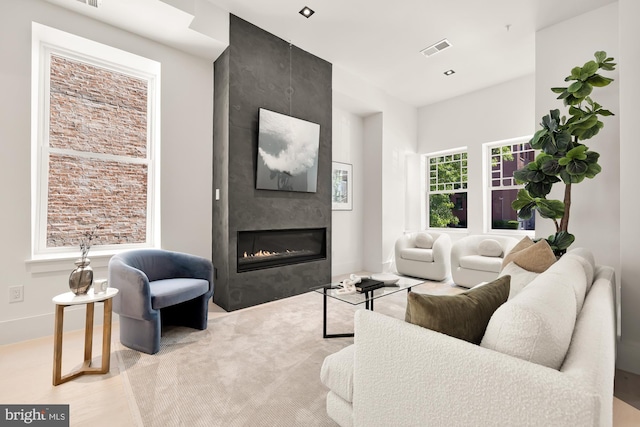 living room with a fireplace and light wood-type flooring