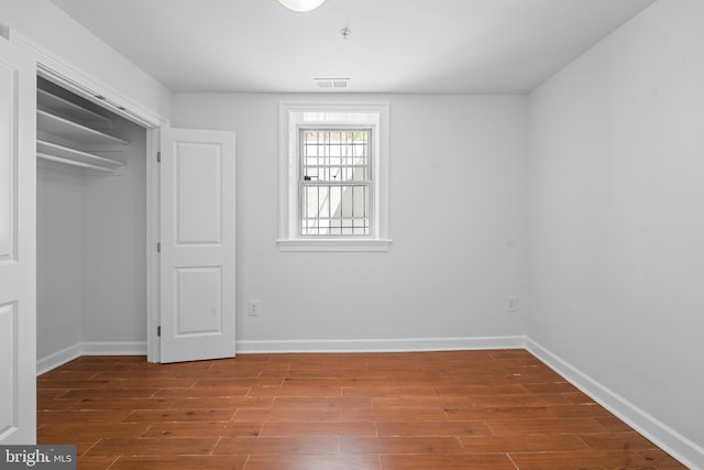 unfurnished bedroom featuring a closet and hardwood / wood-style flooring