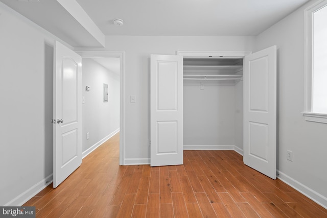 unfurnished bedroom with a closet and light hardwood / wood-style floors