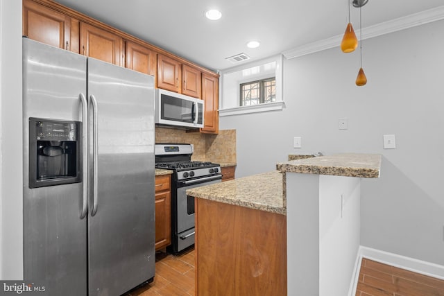 kitchen with kitchen peninsula, appliances with stainless steel finishes, backsplash, light hardwood / wood-style floors, and hanging light fixtures