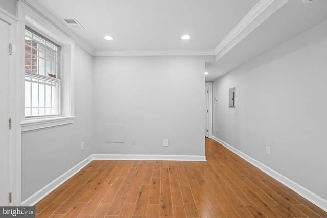 unfurnished room with light wood-type flooring, crown molding, and electric panel