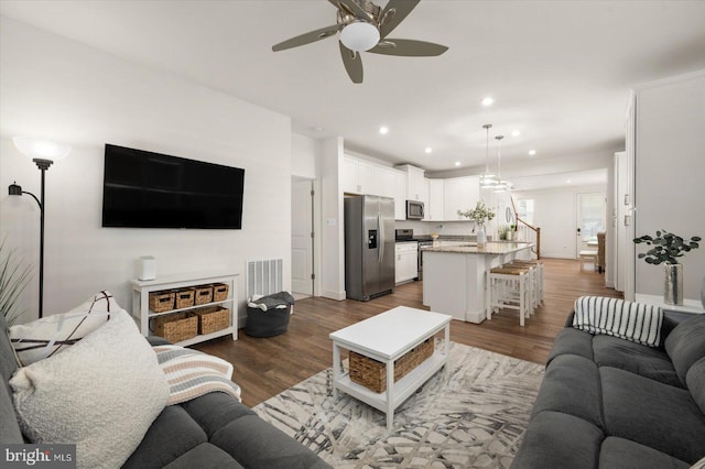 living room with recessed lighting, visible vents, stairway, dark wood-type flooring, and a ceiling fan