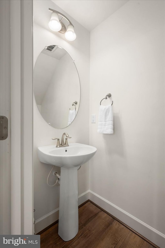 bathroom featuring a sink, baseboards, and wood finished floors