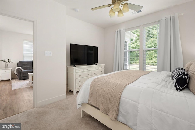 bedroom with visible vents, ceiling fan, light carpet, and baseboards