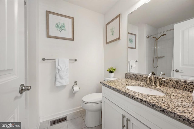 bathroom featuring tile patterned flooring, vanity, toilet, and tiled shower