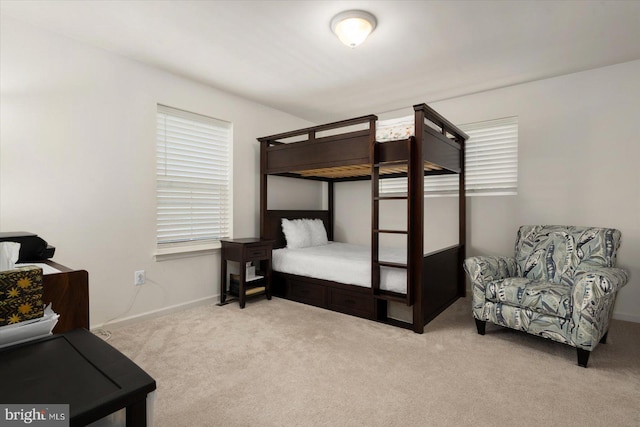 bedroom featuring light colored carpet and baseboards