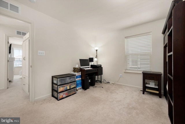 home office with light colored carpet, visible vents, and baseboards