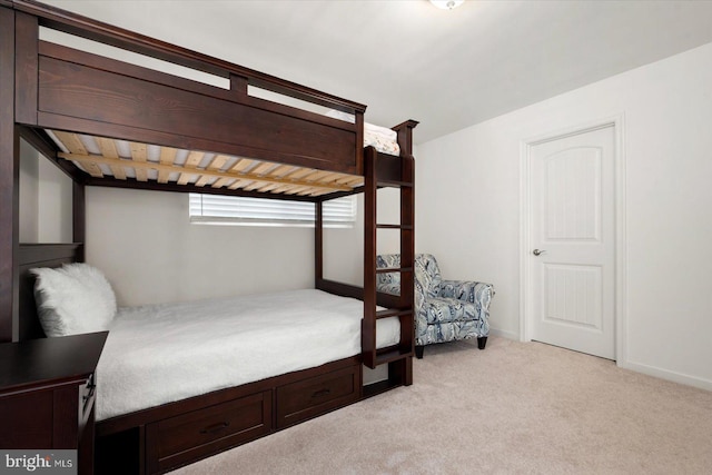 bedroom with light colored carpet and baseboards