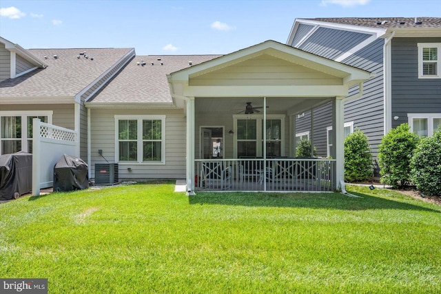 back of house with ceiling fan, central AC, a sunroom, a lawn, and roof with shingles