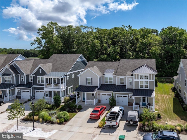 view of property with a residential view, a standing seam roof, metal roof, and an attached garage