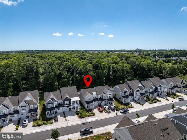 birds eye view of property featuring a residential view and a wooded view