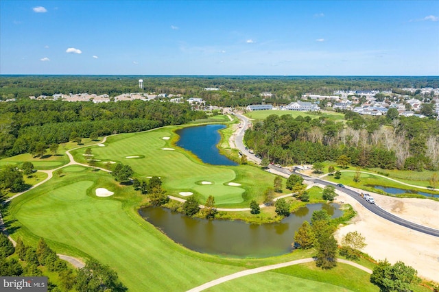 drone / aerial view with view of golf course, a water view, and a forest view