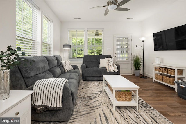 living room with visible vents, dark wood finished floors, and a wealth of natural light