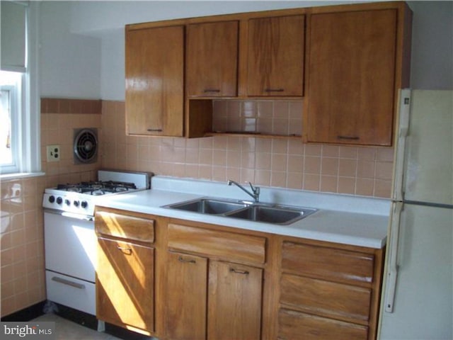 kitchen with white appliances, tasteful backsplash, and sink