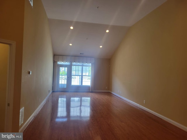 empty room with wood-type flooring and lofted ceiling