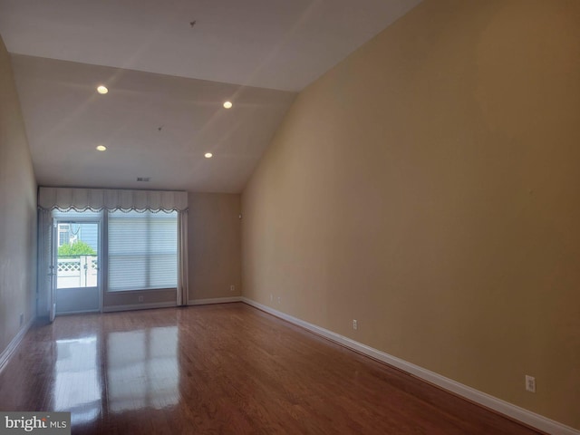 unfurnished room featuring wood-type flooring and lofted ceiling