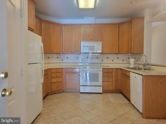 kitchen featuring light tile patterned floors, white appliances, tasteful backsplash, and sink