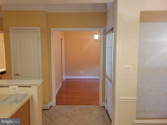 hallway with light hardwood / wood-style floors and ornamental molding