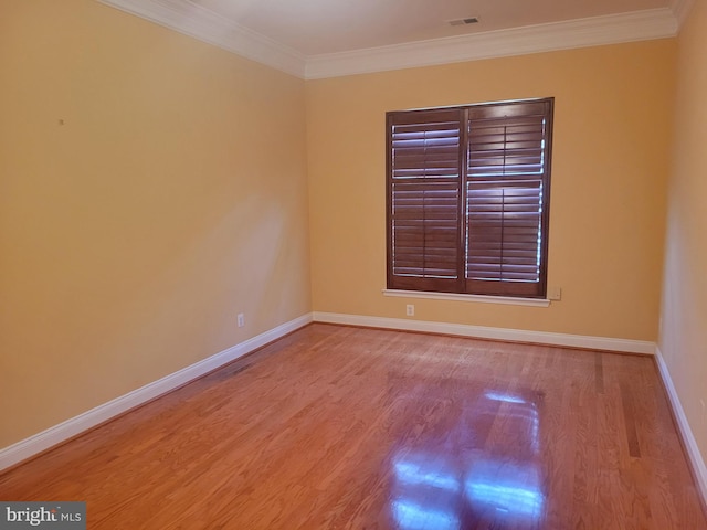 empty room featuring crown molding and light hardwood / wood-style flooring