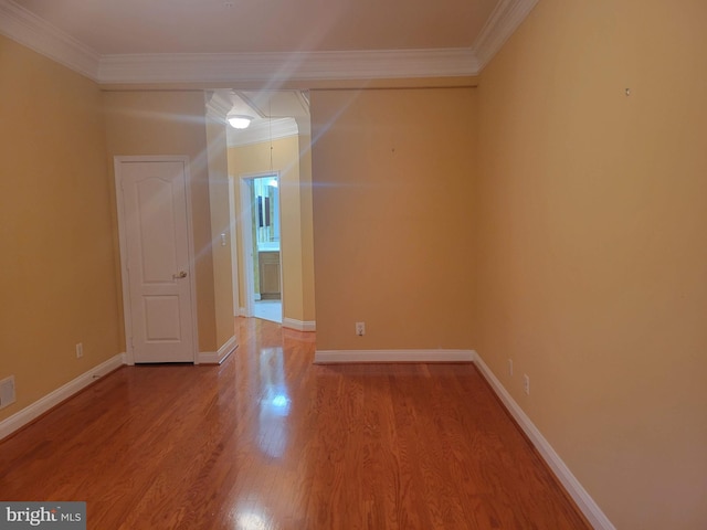 spare room featuring hardwood / wood-style floors and ornamental molding