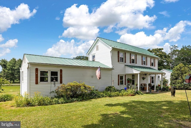 back of house featuring covered porch and a lawn