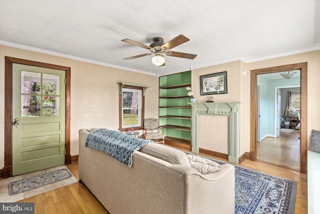 living room with ceiling fan, wood-type flooring, a textured ceiling, and ornamental molding