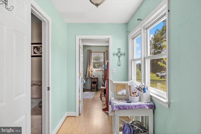 hallway with a wealth of natural light and light wood-type flooring