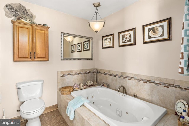 bathroom featuring tile patterned floors, tiled bath, and toilet