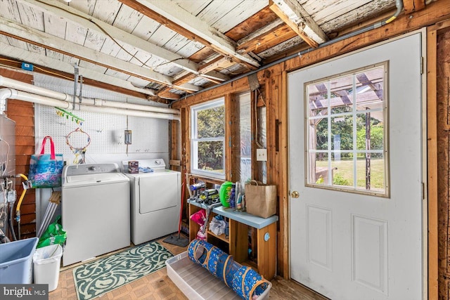 laundry room with washing machine and clothes dryer, a wealth of natural light, and parquet floors