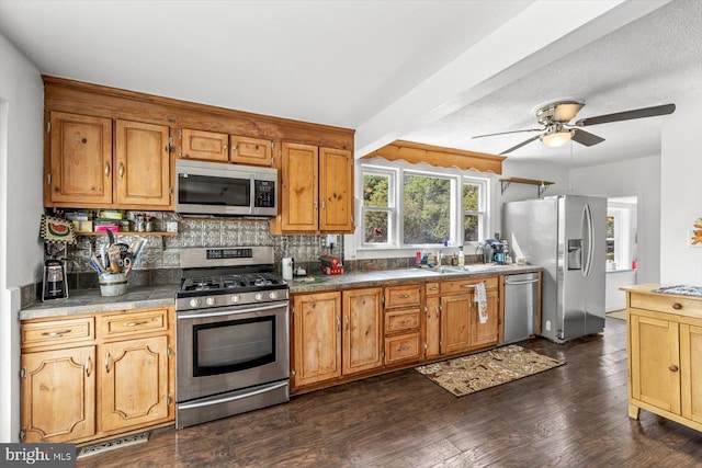 kitchen with backsplash, dark wood-type flooring, ceiling fan, beamed ceiling, and stainless steel appliances