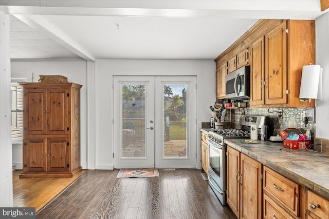 kitchen featuring decorative backsplash, french doors, stainless steel appliances, and dark wood-type flooring