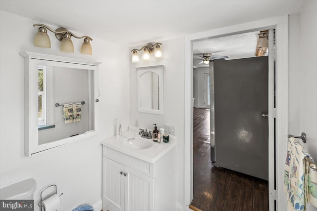 bathroom featuring ceiling fan, vanity, wood-type flooring, and a textured ceiling