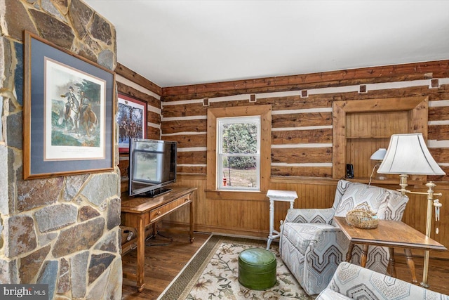 sitting room with wood walls and hardwood / wood-style flooring