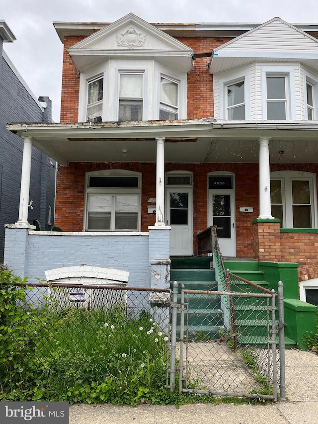 4804 Palmer Ave, Baltimore, MD 21215 - view of property featuring a porch, brick siding, and a gate